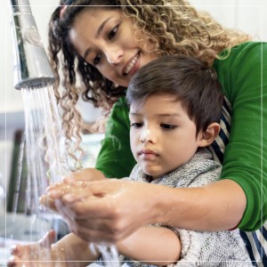 mother helping child wash hands