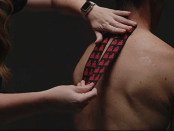 Infrared Kinesiology Tape being placed on a person's back